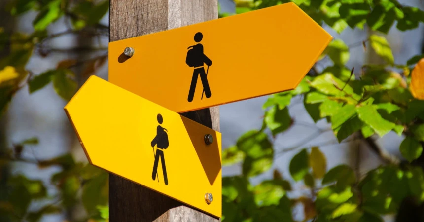Two signs of a human hiking pointing left and right
