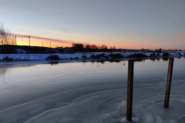 Ice on a canal with a sunrise on the background