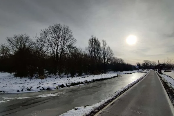 Sunrise with a road alongside a frozen canal