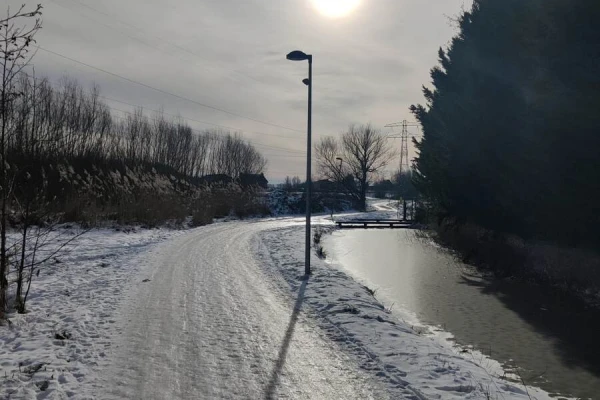 Icy road with the sun behind thin clouds