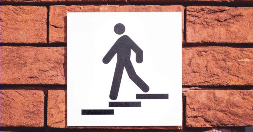 A sign with a symbol of a human walking down a staircase
